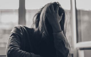 grayscale photography of person covering face