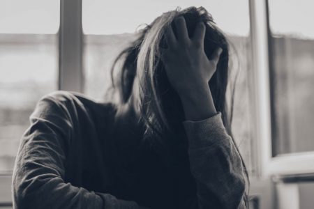 grayscale photography of person covering face